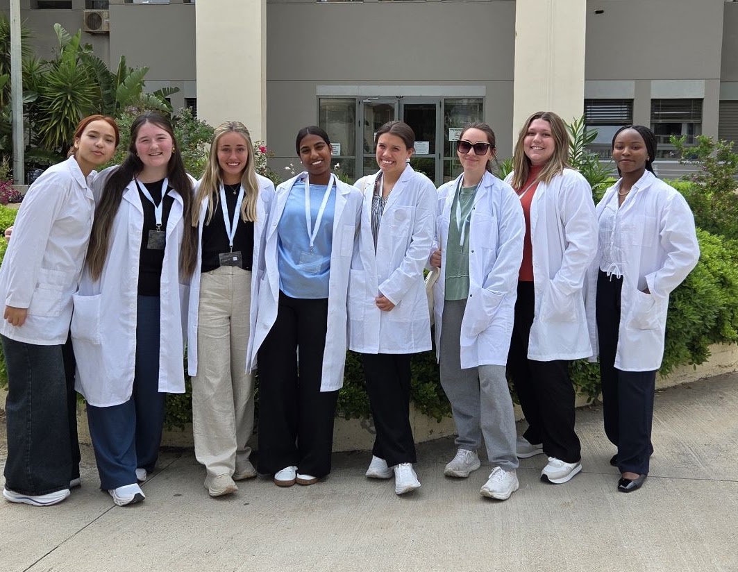 Students in white coats outside a Greek public hospital