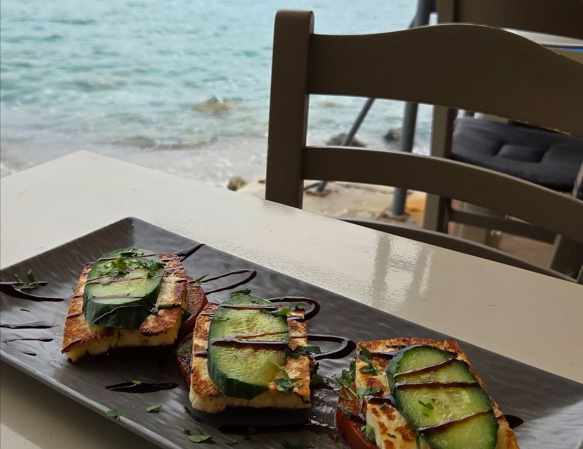 Grilled halloumi with tomato and cucumber at a seaside taverna in Greece